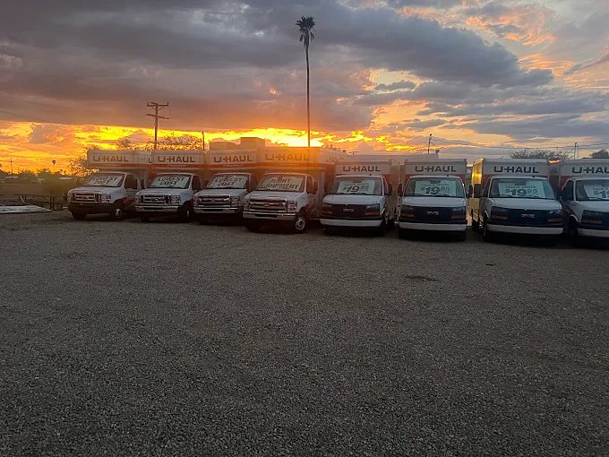 Row of U-Haul vans under an orange sunset